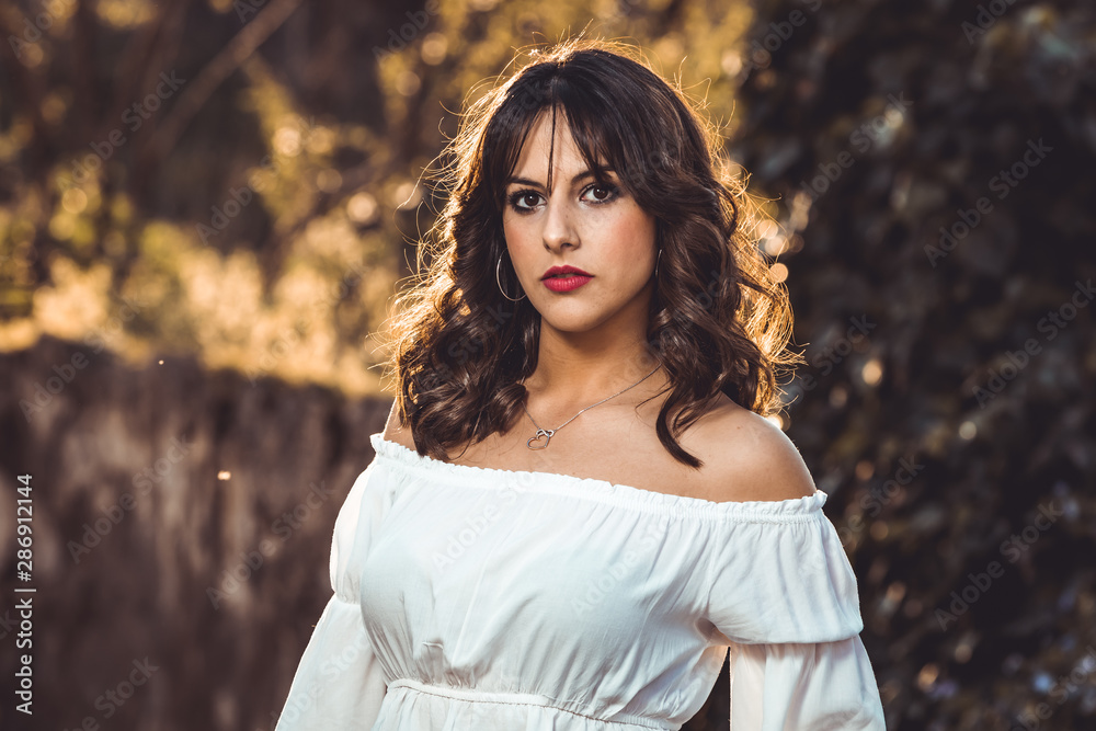 Sunset portrait of beautiful brunette young woman in autumn park Sunset portrait of beautiful brunette young woman in autumn park