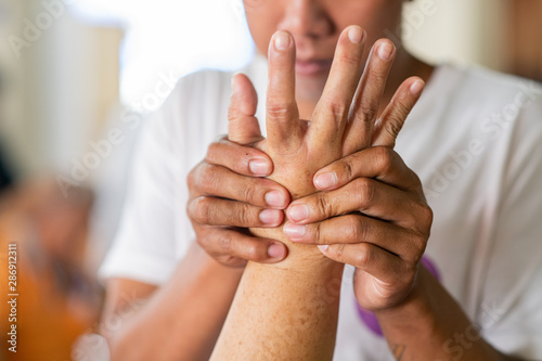 Fototapeta Naklejka Na Ścianę i Meble -  Hands of man doing Thai traditional hand massage at middle finger and pressing at specific spots, health and wellness concept.