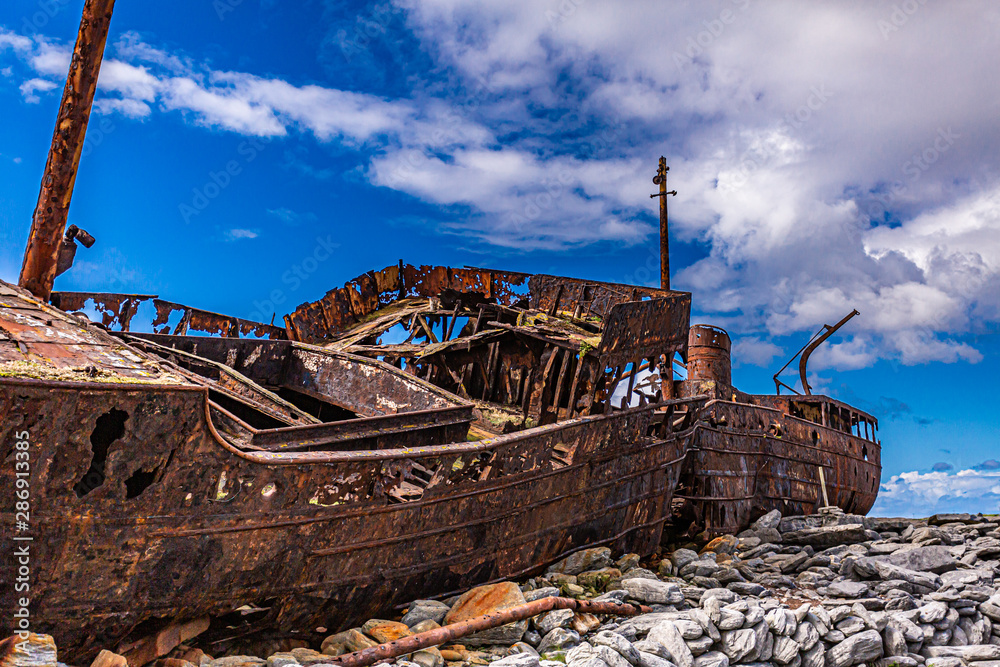 Stunning side view of the of the Plassey shipwreck on the rocky beach of Inis Oirr island, abandoned ship, old and rusty over time, wonderful sunny day in Aran Islands, Ireland