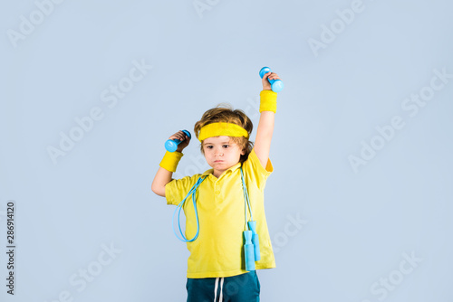 Sporty boy with jump rope and dumbbells. Sport. Fitness child. Child sportsman. Childhood activity. Fitness, health and energy. Boy in sportwear with skipping rope and dumbbells. Success. Gym workout.