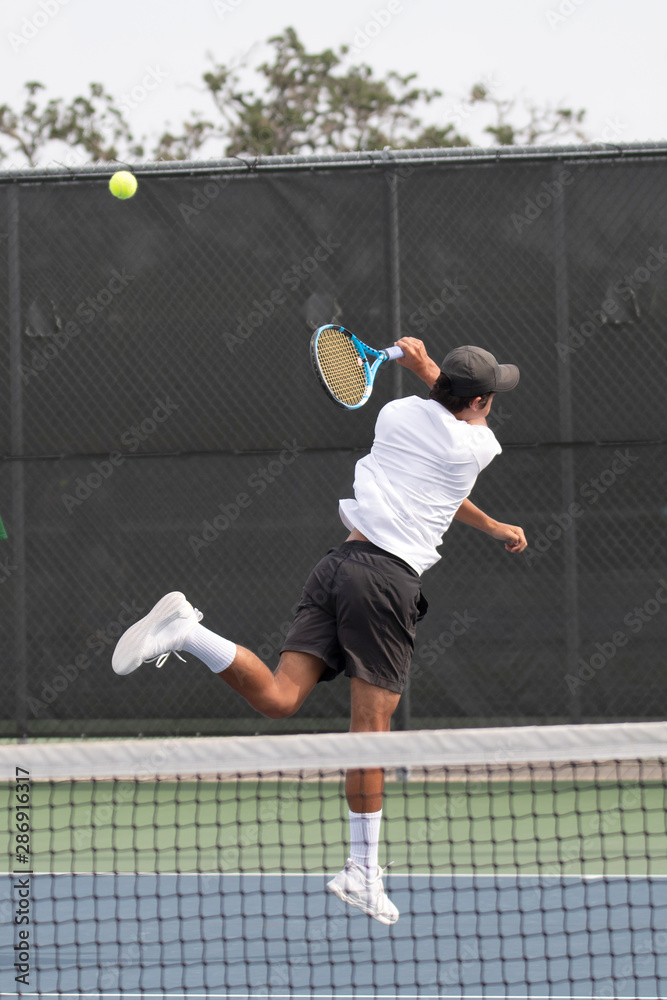 Young boy making a save during a tennis match