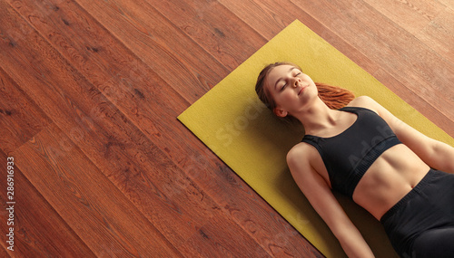 Peaceful woman meditating while lying down on floor