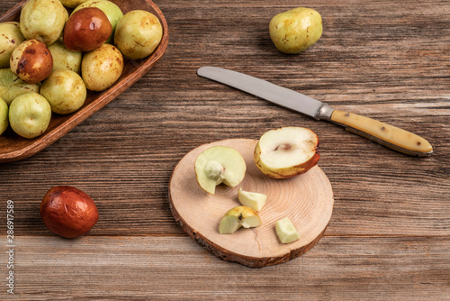 ripe and unripe jujube fruit on cutting board on wooden table