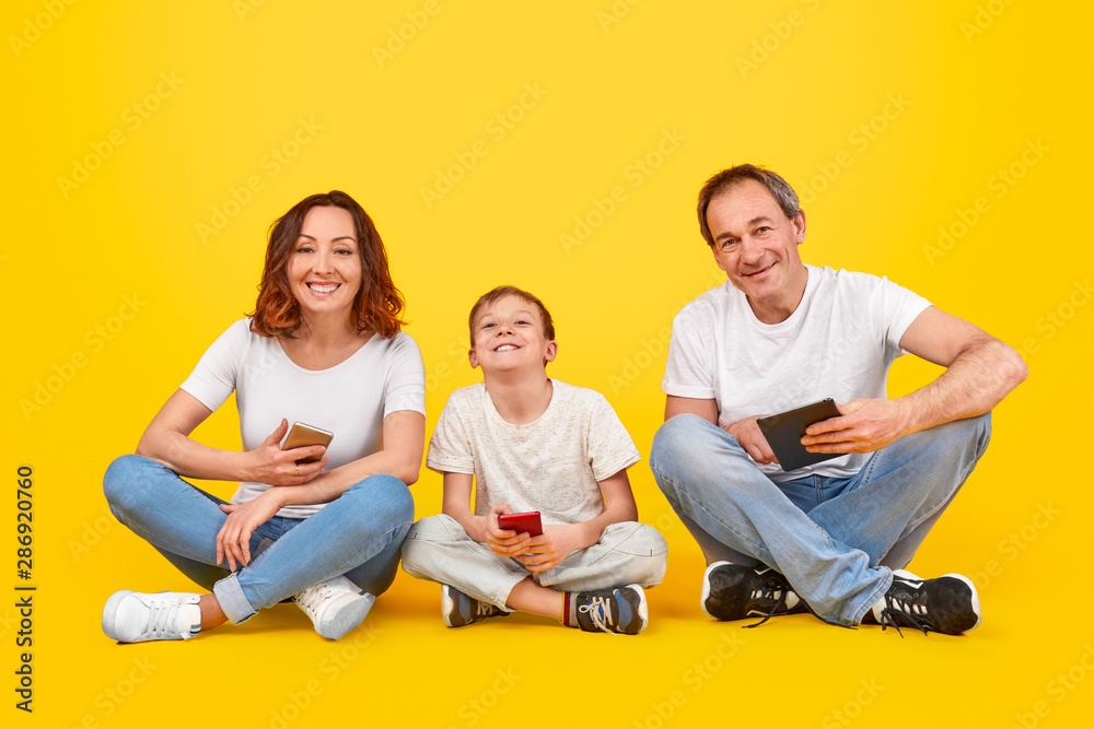 Cheerful family with digital devices