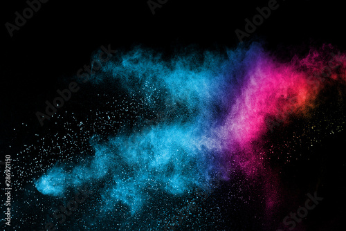 Freeze motion of purple color powder exploding on black background. © piyaphong