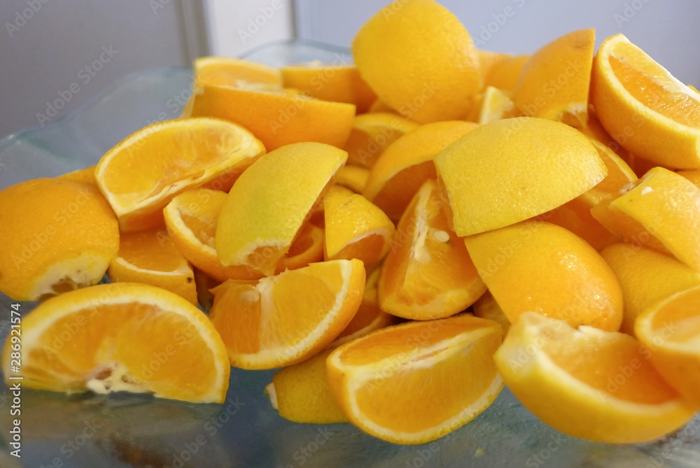 A pile of fresh orange slice in a bowl on a dinning table A pile of fresh orange slice in a bowl on a dinning table