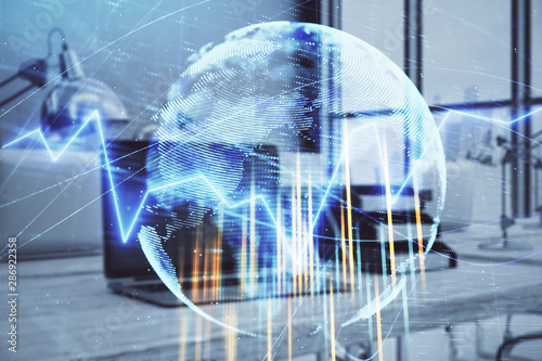 Stock market chart with globe hologram and desktop office computer background. Multi exposure. Concept of financial analysis.