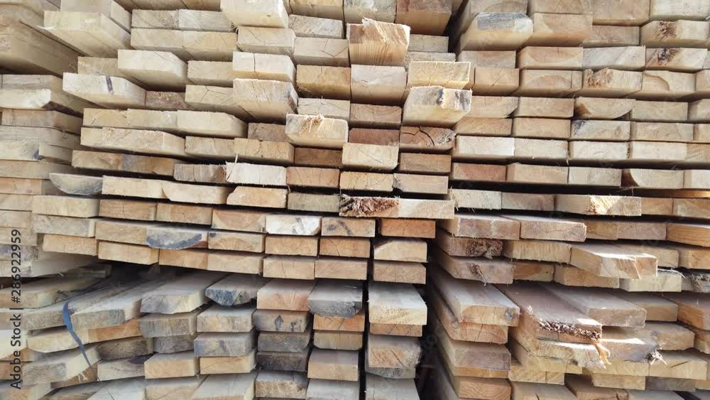 Wooden boards, lumber, industrial wood, timber. Pine wood timber stack of natural rough wooden boards on building site. Industrial timber building materials Wooden boards, lumber, industrial wood, timber. Pine wood timber stack of natural rough wooden boards on building site. Industrial timber building materials