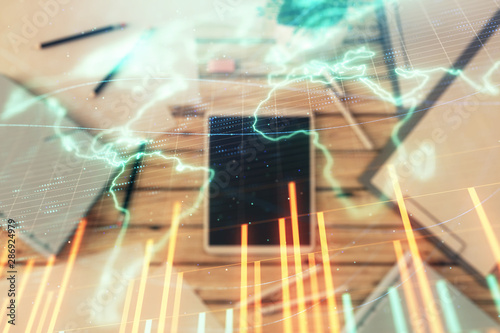 Double exposure of forex chart and world map on digital tablet laying on table background. Concept of market analysis