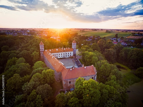 Historical Panemune castle in dramatic sunset conditions with green nature and sun flare in a countryside of Lithuania. Aerial view. photo