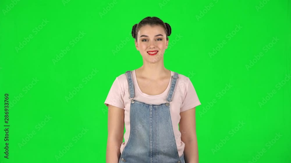 Portrait of smiling girl with two hair-buns on green screen