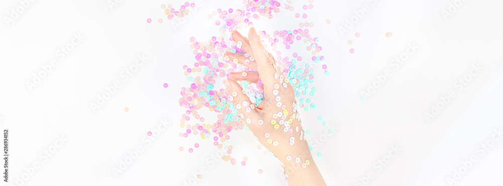 Fototapeta premium Pearl pastel confetti sparkles with woman hand