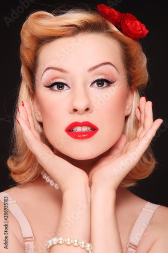 Vintage style portrait of beautiful woman with fancy pin-up makeup and hairdo