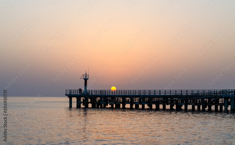 Sea pier in the sea at sunset