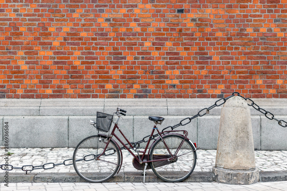Bicycle with basket near the red brick wall. Eco friendly and urban lifestyle concept for transportation in old city Bicycle with basket near the red brick wall. Eco friendly and urban lifestyle concept for transportation in old city