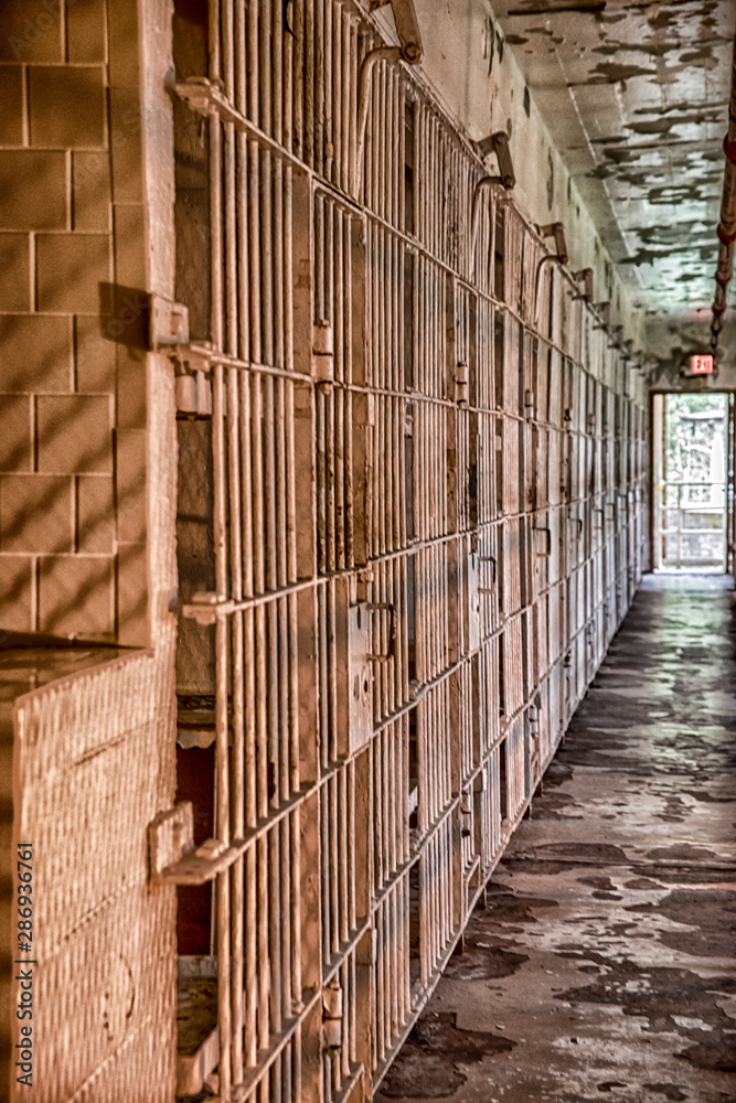 Row of empty cells in old prison in high contrast