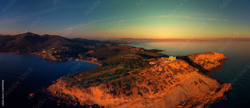 Aerial drone photo of sunset over the iconic Temple of Poseidon at Cape Sounio with amazing golden colours, Attica, Greece