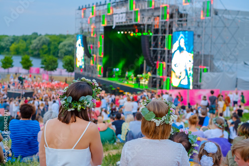Women are watching concert at open air music festival