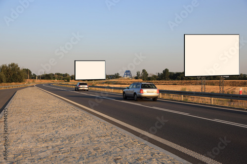 Puste bilbordy reklamowe przy drodze szybkiego ruchu o zachodzie słońca, samochody osobowe. © Stanisław Błachowicz
