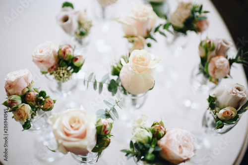 Top-down picture of cream roses in wine glasses