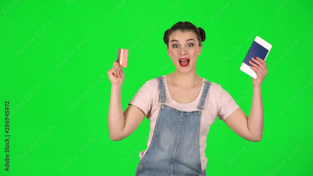 Girl is holding a passport, a plane ticket and credit card very rejoicing and enjoying upcoming trip Girl is holding a passport, a plane ticket and credit card very rejoicing and enjoying upcoming trip