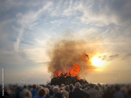 Crowd of people watching a witch burning on a bonfire on the beach at Ski Hans, Fanoe, Jutland, Denmark photo