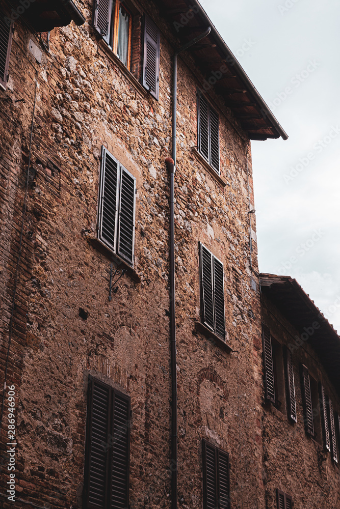 Vintage windows in italian village, brick walls