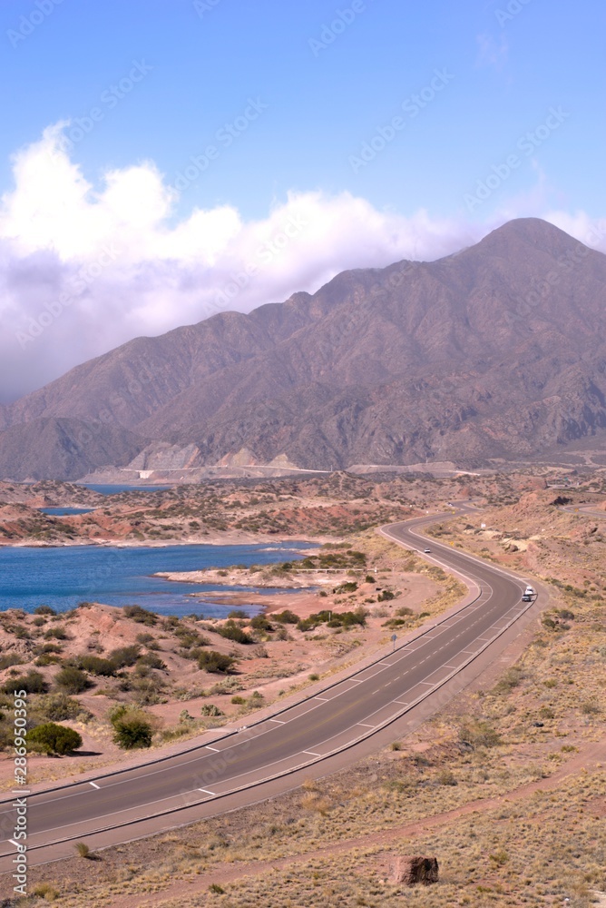 An elevated shot of a stretch of National Route 7 by Lake Potrarillos in the province of Mendoza, Argentina. This national road connects the city of B An elevated shot of a stretch of National Route 7 by Lake Potrarillos in the province of Mendoza, Argentina. This national road connects the city of B