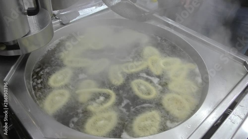 Frying Churros in deep oil in churreria, traditional dough pastry snack. Churros are popular mostly in Spain, dipped in champurrado, hot chocolate, dulce de leche or cafe con leche. photo