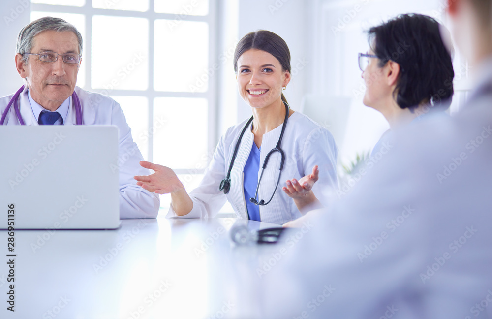 Serious medical team discussing patient's case in a bright office Serious medical team discussing patient's case in a bright office