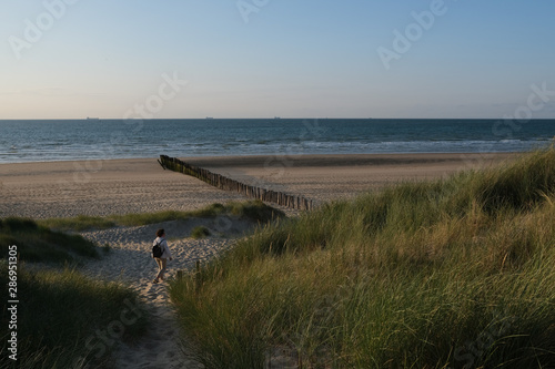 Woman walking on beach, Bleriot Beach, Pas-de-Calais, France photo