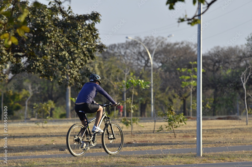 Obraz premium A beautiful view of people walking with bike in Brasilia park, Brazil
