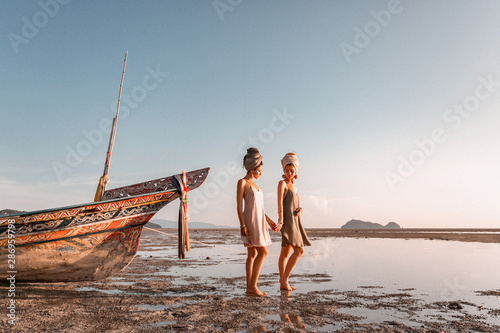 two beautiful young fashion models on the beach at sea boat