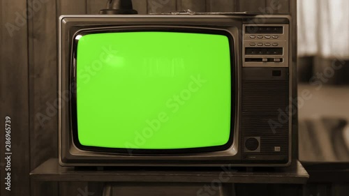 Vintage Television Set Green Background with Noise and Static. Sepia Tone. You can replace green screen with the footage or picture you want with “Keying” effect in AE (check tutorials in internet).  photo