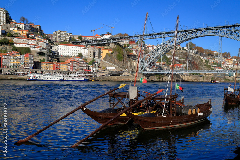 Traditional rabelo boats, Porto city skyline, Douro river and and Dom Luis or Luiz iron bridge. Porto