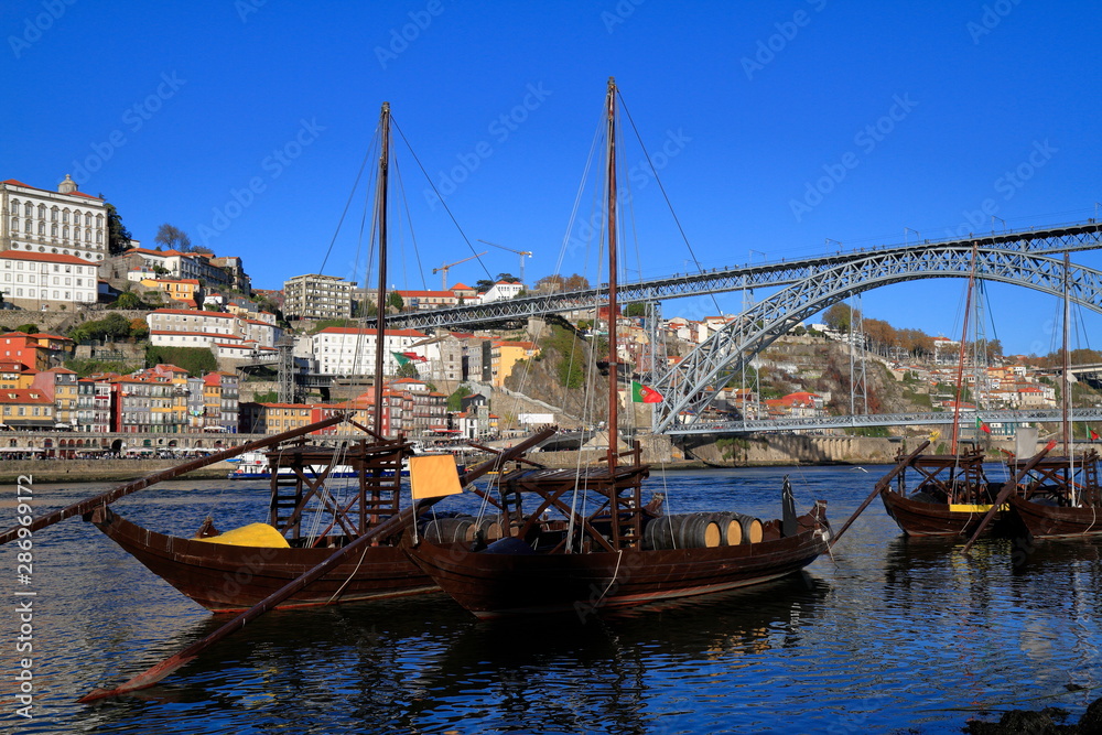 Traditional rabelo boats, Porto city skyline, Douro river and and Dom Luis or Luiz iron bridge. Porto