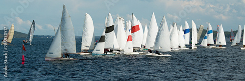 Children sailing in small colourful boats and dinghies in Australian high school championships.