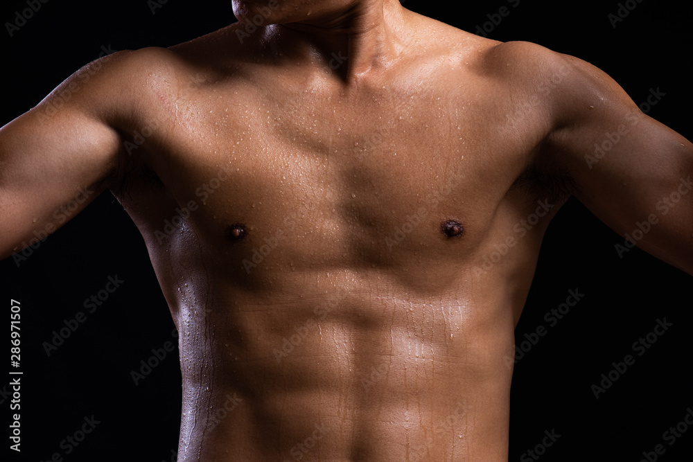 Sweat. Closeup of a strength fitness body with sweat. Fit young man with beautiful torso. Bodybuilder and muscular body concept.