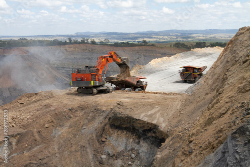 Excavator loading trucks