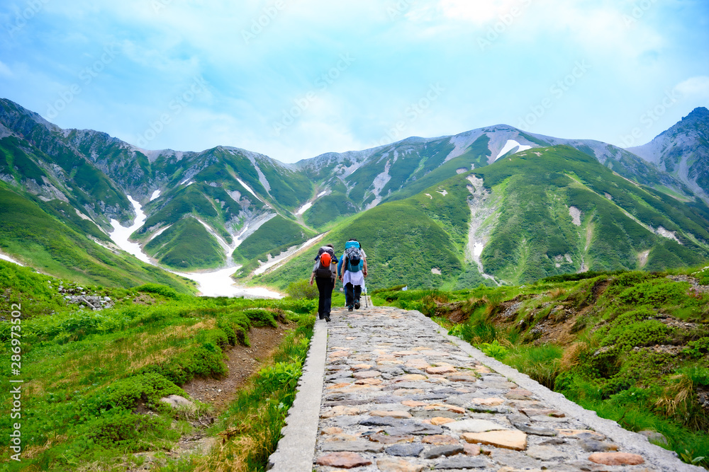 雷鳥沢に向かう登山者、立山の美しい山々を背景に