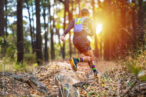 A man Runner of Trail and athlete's feet wearing sports shoes for trail running in the forest