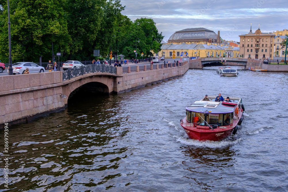 Naklejka premium boat sailing along the Fontanka river at sunset