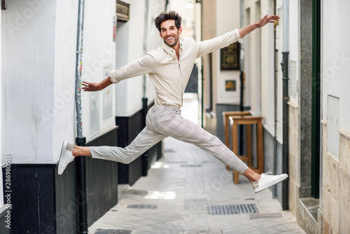 Young happy man jumping in the street.
