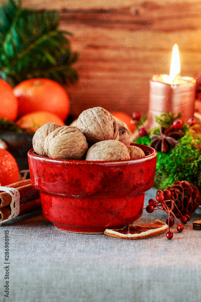 Bowl with walnuts and Christmas decorations in the background. Bowl with walnuts and Christmas decorations in the background.
