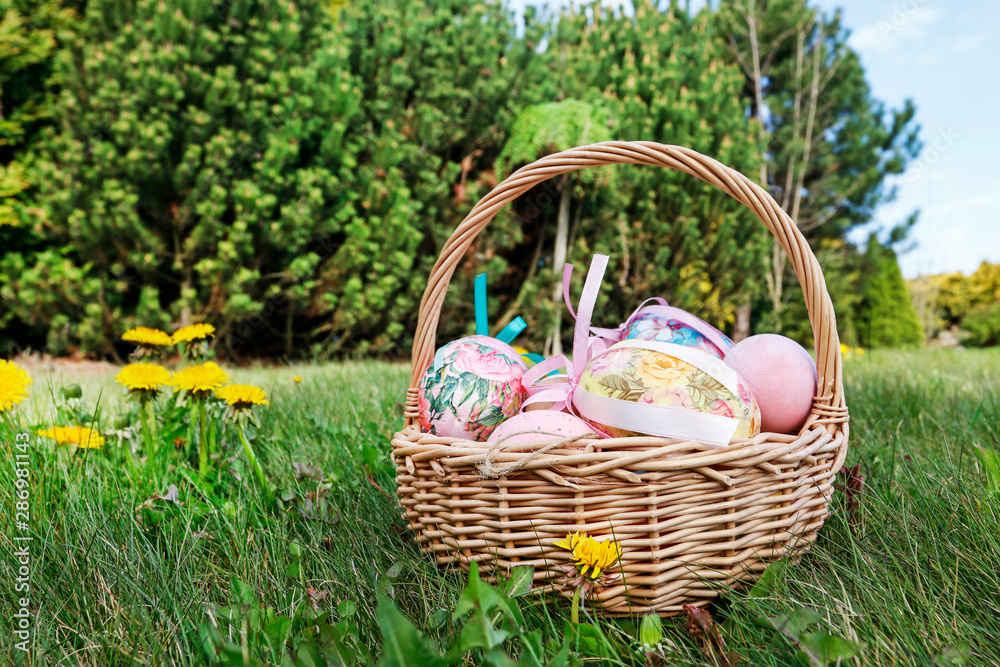 Wicker basket with Easter eggs in the garden. Wicker basket with Easter eggs in the garden.