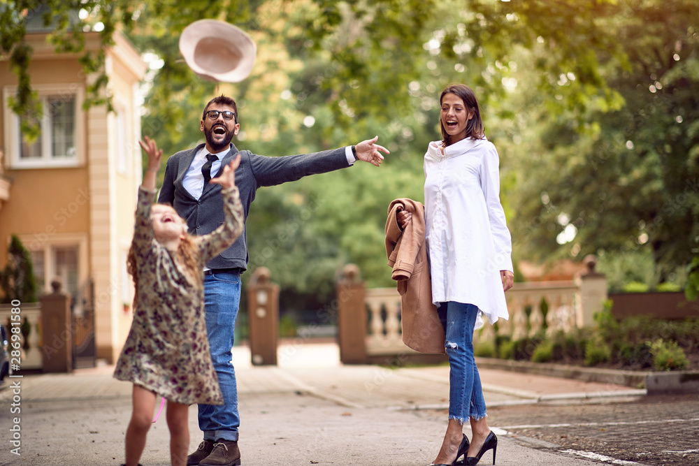 Obraz premium Mother and father with pupil having fun in park after school.