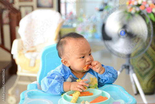 Asian baby boy 6 months old eating with Baby Led Weaning (BLW) method, Self-Feeding