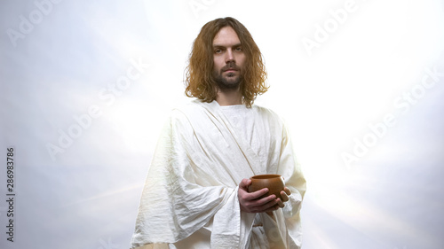 Obraz na płótnie God looking at camera with clay pot in hands, concept of helping needy people