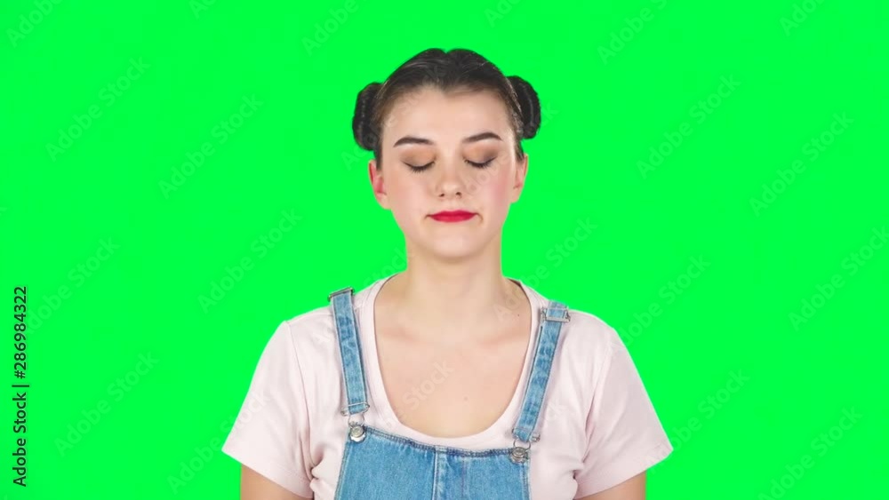Girl angry covering her ears with her hands on green screen at studio, slow motion. Girl angry covering her ears with her hands on green screen at studio, slow motion.
