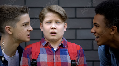 Quadro em tela Teenage friends teasing boy, provoking to do bad things, negative influence